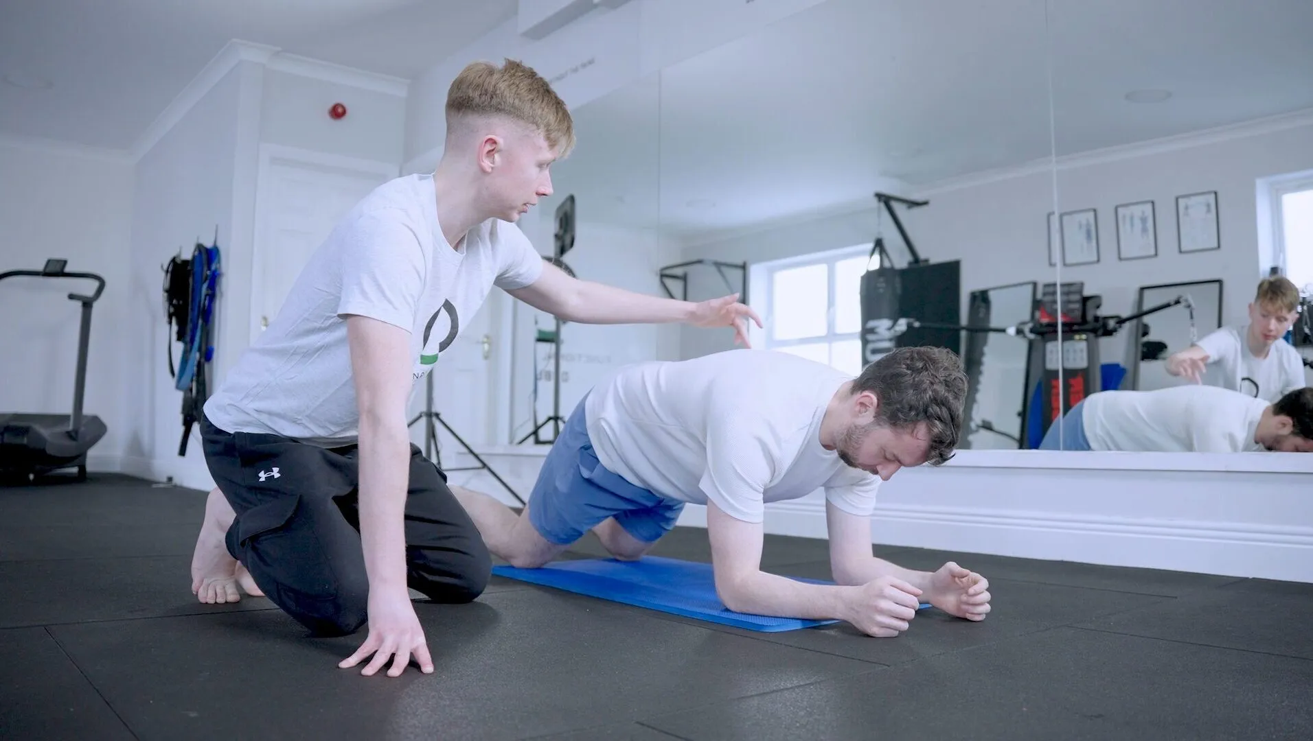 A practitioner coaching a client through a floor exercise