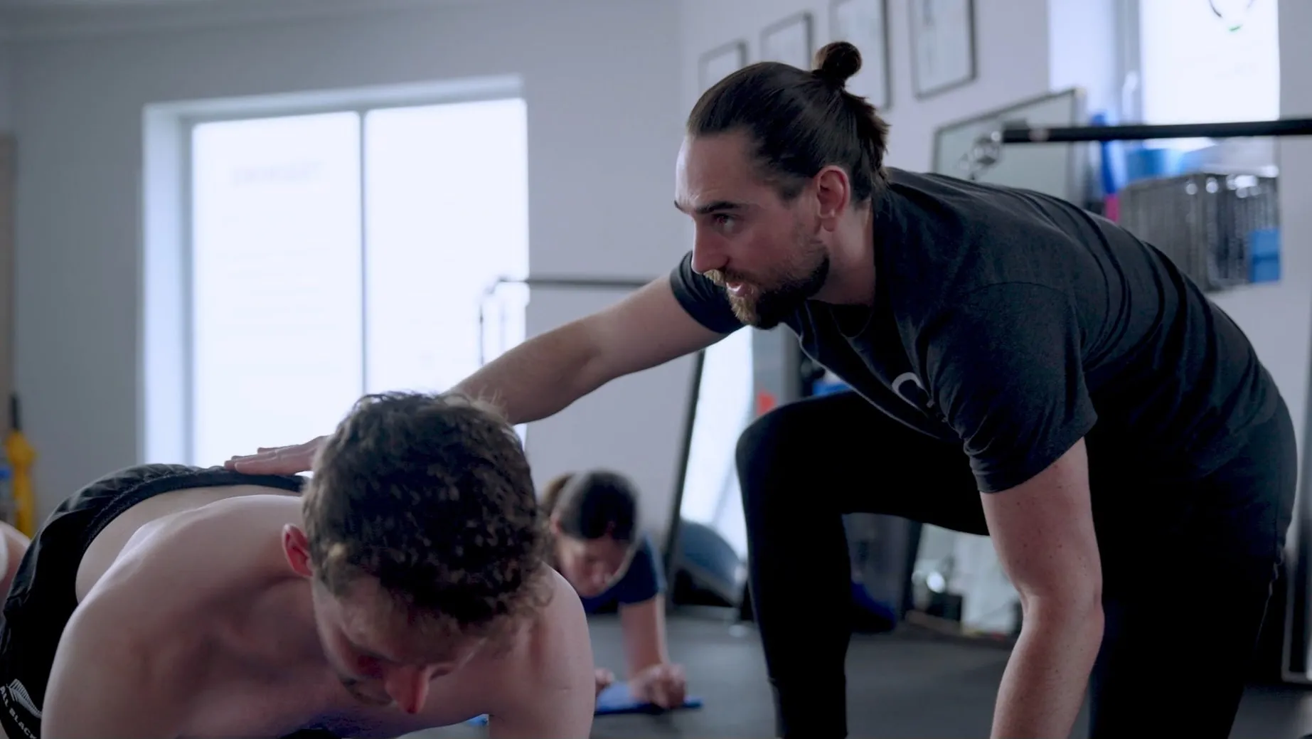 A practitioner coaching a client on the training floor
